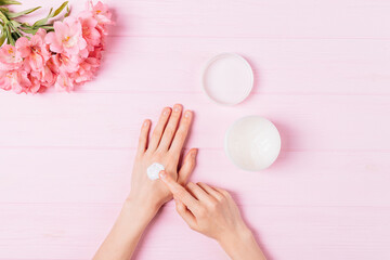 Obraz na płótnie Canvas Female hands apply cosmetic moisturizer balm