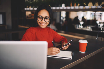 Portrait of afro american student sitting in coffee shop on break looking at camera 