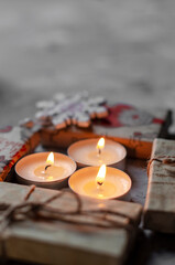 Christmas, New Year's gifts are packed in kraft paper on a table with candles and a Christmas wreath