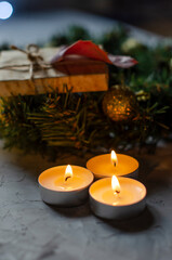 Christmas, New Year's gifts are packed in kraft paper on a table with candles and a Christmas wreath