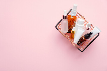 Shopping basket with natural organic cosmetics on pink background. Beauty store discount sale banner mockup. Flat lay, top view.