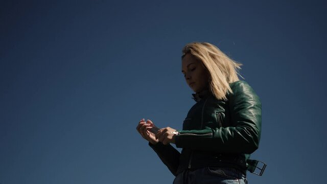 young woman sawing the nails in the street sawing