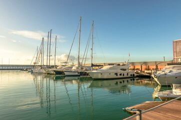 Obraz na płótnie Canvas Marina with walkway and boats at sunset