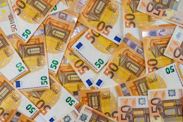 Fototapeta na wymiar Banknotes of 50 fifty euros are scattered in a chaotic manner. European currency blank for design, background. View from above.