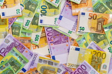 European currency lies on the table. Banknotes five hundred, one hundred, two hundred, fifty euros are scattered in a chaotic manner. Blank for design, background. Close-up. View from above.