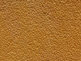 Background Gold Yellow Color textures of decorative plaster on the wall of the house.