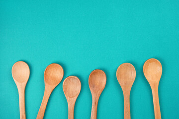 Wooden spoons set on bright turquoise background. Culinary, cooking concept. Top view, copy space,...