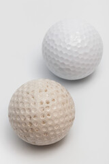 old and new golf ball on white background