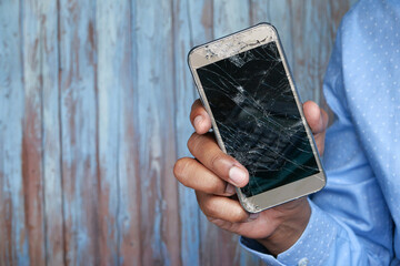 Close up of man hand holding broken smart phone 