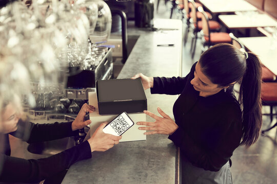Owner and coworker with modem box at checkout counter in cafe