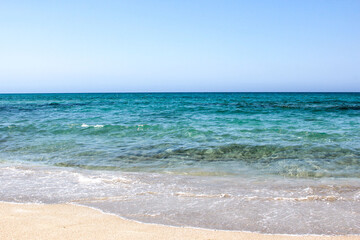 Fototapeta na wymiar Coast with waves as a background. Blue water seascape. Summer.
