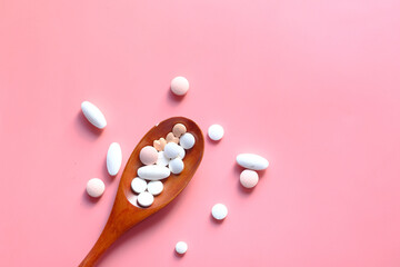 high angle view of pills on spoon on pink desk 