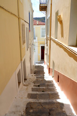 One of the charms of the Greek Cycladic Islands, in the heart of the Aegean Sea are the narrow streets: white houses, small flowered balconies and cobbled stairs