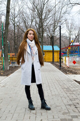 The girl is walking in the park. Read a book.