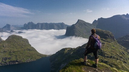 Lofoten isnalds, Norway hiking - Man hiking in pristine mountains above the clouds
