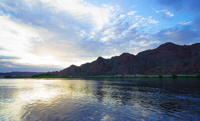 Sunset in the steppe in a river valley. Beautiful sunset. Landscape in the steppe, Prairie. Landscape in the evening. The clouds.
