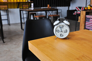 The clock is on the table in the coffee shop.