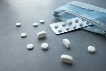 Fototapeta na wymiar Close up of white pills spilling on dray desk 