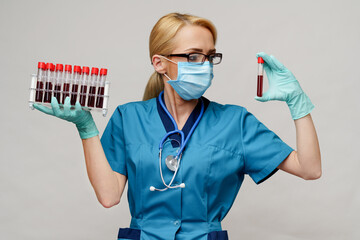 medical doctor nurse woman wearing protective mask and gloves - holding rack with virus blood tests