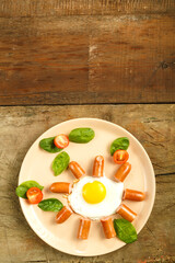 Fried eggs with sausages in the shape of a sun. Children's breakfast.