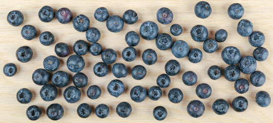  blueberry berries on light wooden background top view