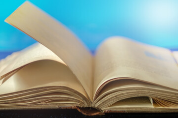 Old vintage opened book on a light blue background