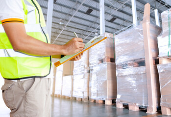 Warehouse worker holding clipboard and checking order shipment goods. warehouse inventory management.