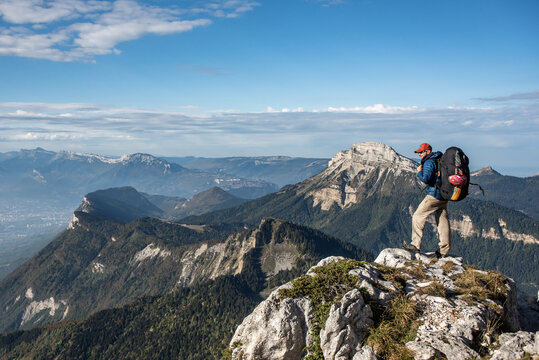 Young man standing on the top of a mountain overlooking a beautiful view