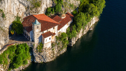 Fototapeta na wymiar Aerial view of the hermitage of Santa Caterina del Sasso Ballaro. The rock structure is a monastery built overhanging the eastern shore of Lake Maggiore, near Varese, Italy.