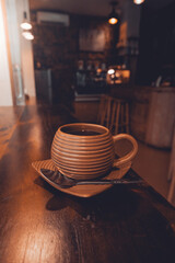 Primero plano café en vaso de barro dentro de una cafetería solo en vertical