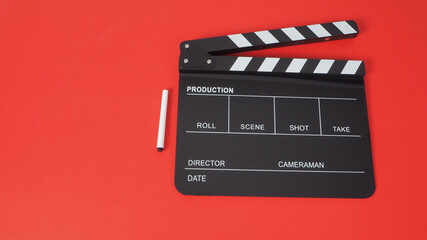Fototapeta na wymiar Pen with black Clapperboard or movie slate use in film production and cinema industry on red background.