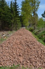 Baumaterial zur Befestigung lagert auf Waldweg - Fortswirtschaft