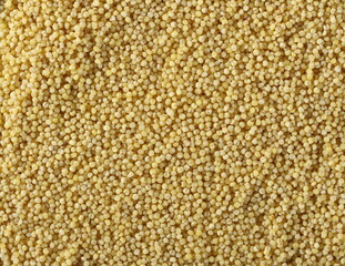 Peeled yellow millet seeds, organic food product background and texture