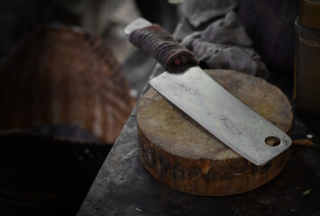 An old knife is on the kitchen cutting board