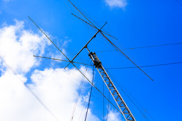 Ham radio antenna against cloudy sky.