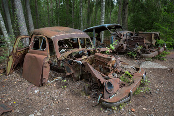 Old cars in Sscrapyard in forest in Ryd Sweden