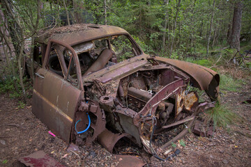 Old cars in Sscrapyard in forest in Ryd Sweden