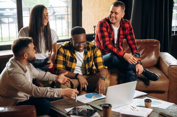 Modern business team in the office. Successful colleagues in modern casual wear gathered at a common table to analyze the results of joint work on the project