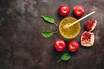 Apples, pomegranate and honey on a dark rustic background. Jewish New Year - Rosh Hashanah. Traditional Jewish food. Top view, flat lay,copy space.