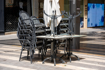 folded tables and chairs in a closed street cafe