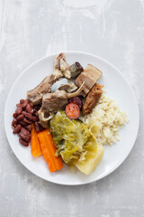 typical portuguese dish boiled meat, smoked sausages, vegetables and rice on white plate