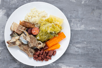 typical portuguese dish boiled meat, smoked sausages, vegetables and rice on white plate