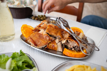 roasted piglet with orange on dish in restaurante