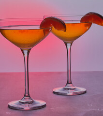 Glasses of orange martini,shot with a red gradient background.