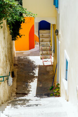One of the charms of the Greek Cycladic Islands, in the heart of the Aegean Sea are the narrow streets: white houses, small flowered balconies and cobbled stairs
