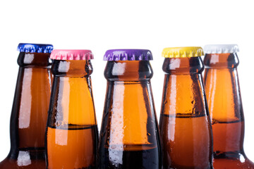 Brown beer bottles over white background. Beer with colored caps. Close up view of drinks with copy space.