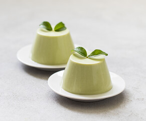 Panna cotta with green matcha tea on a light background
