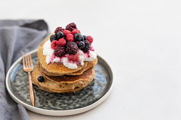 Oatmeal pancakes stacked on each other and topped with yogurt an