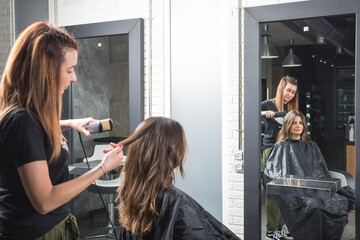 Profesional de peluquería trabajando, peinando, tiñendo y cortando cabello.
