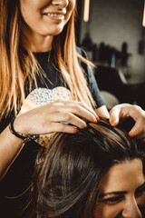 Profesional de peluquería trabajando, peinando, tiñendo y cortando cabello.